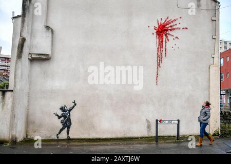 Une nouvelle œuvre d'art sur le côté d'une maison sur Marsh Lane, Barton Hill, Bristol, qui est considéré par l'artiste de rue Banksy. Le pochoir noir et blanc d'une fille avec un catapulte et la peinture splat, fait de roses et de fleurs en plastique, est dans le style de Banksy, mais doit encore être confirmé comme étant l'œuvre de l'artiste. Photo PA. Date De L'Image: Jeudi 13 Février 2020. Crédit photo devrait lire: Ben Birchall/PA Wire Banque D'Images