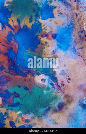 Les gouttes de différentes couleurs de peinture sont mélangées et absorbées. Taches de peinture abstraites sur le papier blanc Banque D'Images