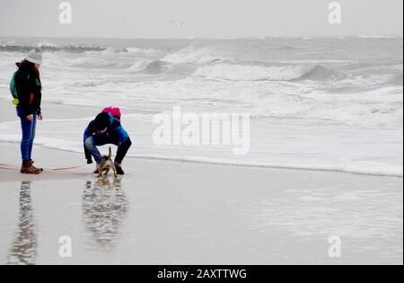 13 février 2020, Schleswig-Holstein, Wenningstedt/Sylt: Les marcheurs marchent le long de la plage de l'île de la mer du Nord Sylt. Après la tempête 'Stabine', les dégâts aux plages ont été déterminés ici. Photo: Carsten Rehder/Dpa Banque D'Images
