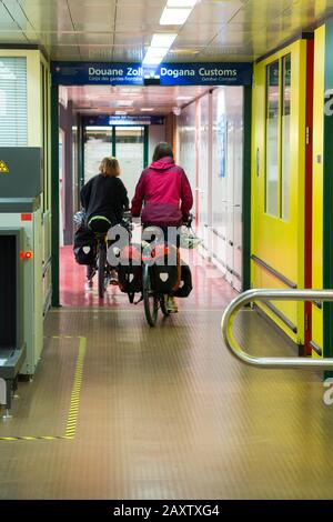 Deux cyclistes touristiques en vélo / passer par douane / Douanes au passage frontalier entre la France et la Suisse à la gare de Genève. (112) Banque D'Images