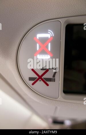 Les avions « pas de téléphone mobile / téléphone / appareil électronique » et « pas de fumeur » s'allument et s'allument pendant le vol dans un avion / avion Bombardier. (112) Banque D'Images