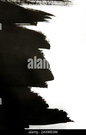 noir abstrait coups de pinceau improvisés sur papier blanc avec une main isolée Banque D'Images