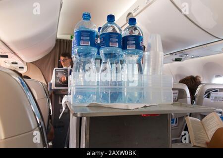 Un membre de l'équipage de cabine avec un chariot pour boissons nautiques livre des rafraîchissements aux passagers Economy dans leurs sièges sur un avion Bombardier passagers avion / avion / avion / avion / avion. (112) Banque D'Images