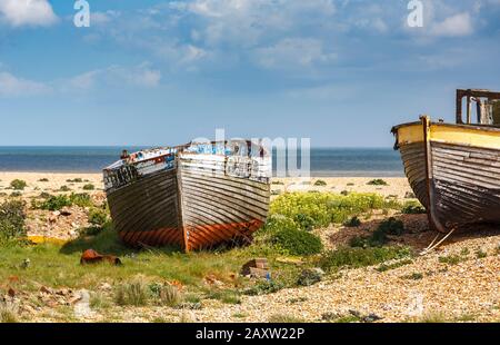 Decying coque de vieux bateaux de pêche en bois abandonnés sur la plage de galets à Dungeness, district de Shepway, Kent, le printemps ensoleillé Banque D'Images