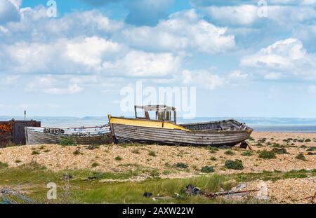 Decying coque de vieux bateaux de pêche en bois abandonnés sur la plage de galets à Dungeness, district de Shepway, Kent, le printemps ensoleillé Banque D'Images