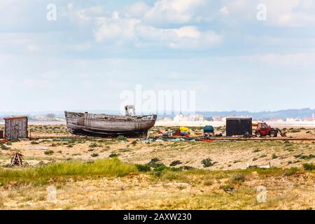 Délabrant coque d'un vieux bateau de pêche en bois abandonné sur la plage de galets à Dungeness, district de Shepway, Kent, lors d'une journée de printemps ensoleillée Banque D'Images