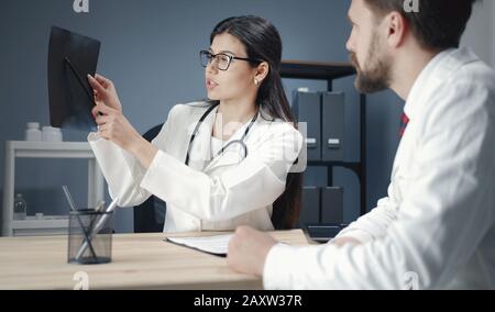 Médecins qui regardent les résultats des rayons X. Banque D'Images