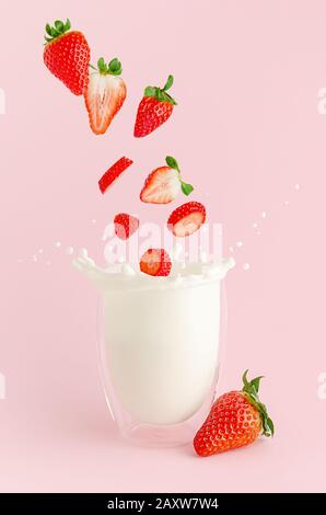 Chute de fraises dans le verre avec projection de lait. Concept de lévitation de cocktail d'été. Banque D'Images