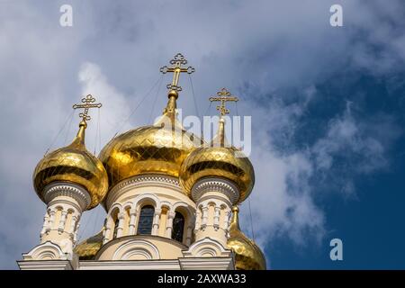 Dômes dorés de la cathédrale Saint-Alexandre Nevsky contre un ciel bleu et des nuages blancs. Banque D'Images