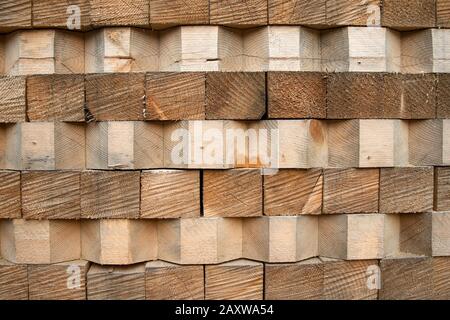 Pile de bois avec poutres en bois biseautées, texture. Gros plan photo de poutres en bois empilées en usine Banque D'Images