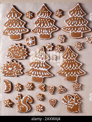 Biscuits au pain d'épice de Noël sous forme d'arbres et d'animaux forestiers sur papier parchemin Banque D'Images