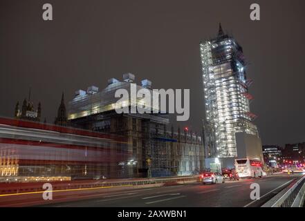 La circulation au-dessus du pont Westminster laisse des sentiers légers avec Big Ben et une partie des Chambres du Parlement couvertes par des échafaudages. Banque D'Images