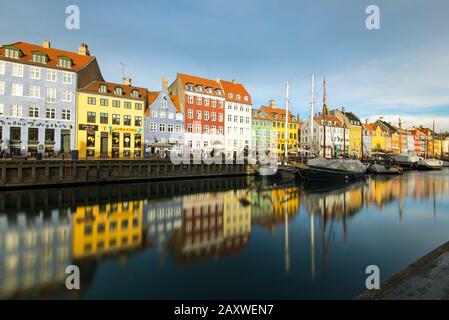 Longue exposition à la vue emblématique du Danemark sur Nyhavn dans le centre de Copenhague avec ses bâtiments peints colorés et ses bateaux garés. Banque D'Images