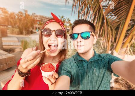 Un couple heureux qui mange de la glace savoureuse au complexe de la mer. Concept de vacances et voyage ensemble Banque D'Images