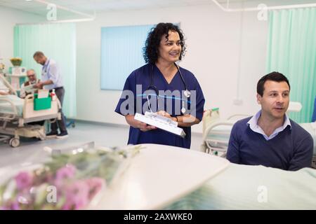 Médecin avec dossier médical effectuant des rondes dans le service hospitalier Banque D'Images