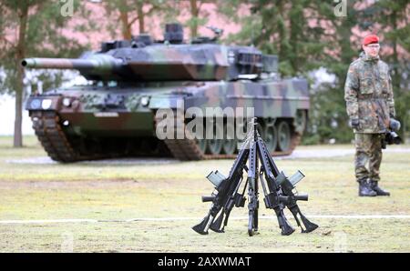 Strausberg, Allemagne. 13 février 2020. Un pétrolier est debout dans la caserne de von-Hardenberg pour le transfert de commandement sur l'armée allemande devant un char Leopard 2 et des fusils montés du type G-36 de Heckler & Koch. Crédit: Wolfgang Kumm/Dpa/Alay Live News Banque D'Images