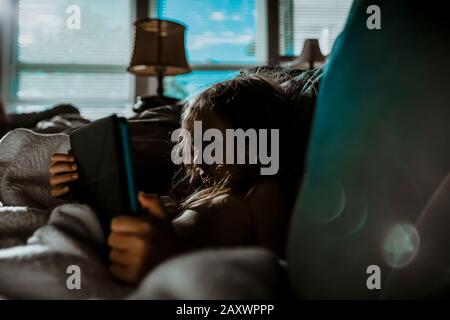 Fille regardant ses bandes dessinées et ses vidéos sur sa tablette Banque D'Images