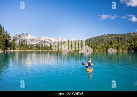 Femme active pagaies Stand up paddle board sur le lac bleu. Banque D'Images