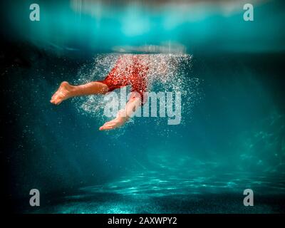 Photo sous l'eau d'un garçon nageant dans une piscine Banque D'Images