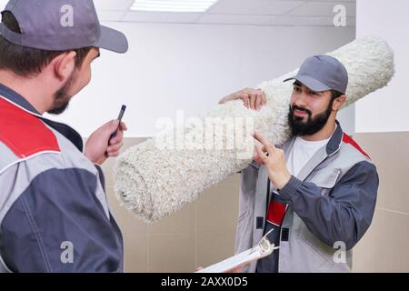 Heureux homme portant un tapis dans la nouvelle maison Banque D'Images