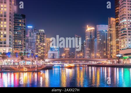 Nuit vue colorée sur la célèbre attraction touristique de la ville de Dubaï - Port maritime de Marina et gratte-ciel éclairés. Voyages et biens immobiliers en unité Banque D'Images