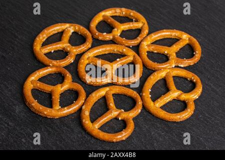 Groupe de sept bretzel brun salé entier sur la pierre grise Banque D'Images