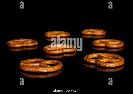 Groupe de sept bretzel brun salé isolé sur le verre noir Banque D'Images