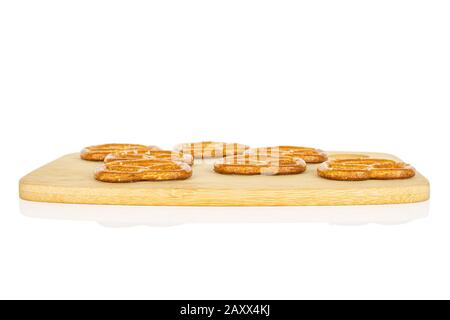 Groupe de sept bretzel brun salé entier sur planche à découper en bambou isolé sur fond blanc Banque D'Images