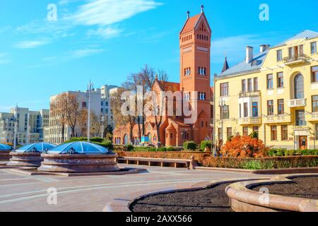 Place de l'indépendance avec dômes en verre et vue sur l'église catholique Saint-Simon et Sainte-Hélène (église rouge) à Minsk. Biélorussie Banque D'Images