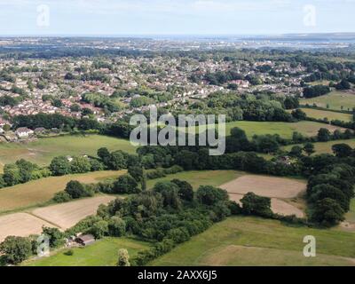 Vue aérienne sur la campagne et le bord d'une ville, Corfe Mullen, en regardant vers Poole Harbour au loin Banque D'Images