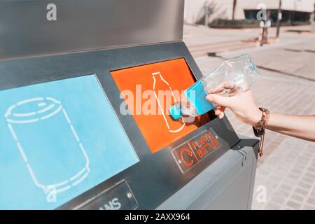 Une fille trie et jette les ordures dans une station de rue pour le recyclage des déchets plastiques. Concept de conservation de l'environnement Banque D'Images