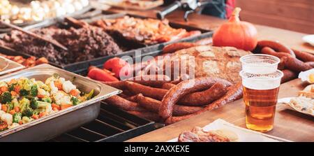 Toutes sortes de délicieux plats savoureux et verres en plastique de bière avec fond de bannière en mousse. Barbecue, grill, différents types de nourriture. Légumes grillés Banque D'Images