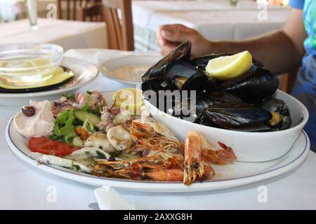 Assiette de fruits de mer avec moules, calmars, poulpe et petits homards sur une salade. Fruits de mer grecs. Banque D'Images