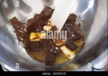 Les côtelettes de beurre et de chocolat fondent dans un bol à mélanger en acier inoxydable bain marie, un concept de cuisson et de préparation de nourriture Banque D'Images