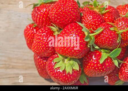 Fraises rouges mûres sur une vieille table en bois Banque D'Images