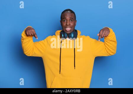 La photo horizontale du jeune homme d'Afrique américain pointe les deux index vers le bas, Banque D'Images