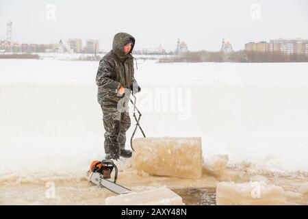 Le monteur avec pinces en acier sort le bloc de glace Banque D'Images