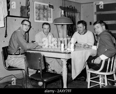 Un groupe d'hommes jouent des cartes dans leur cabane de chasse dans le Wisconsin, ca. 1960. Banque D'Images