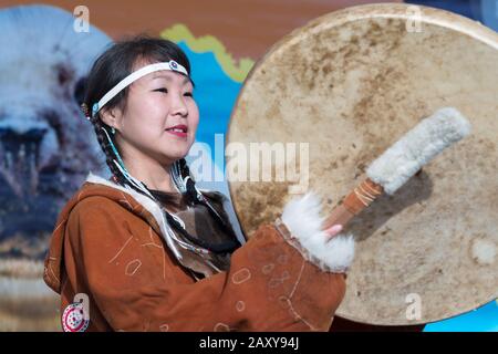 Femme dansant avec de la tambourine dans des vêtements traditionnels aborigènes personnes Kamchatka. Concert, célébration de la fête nationale Koryak Hololo Day of Seal Banque D'Images