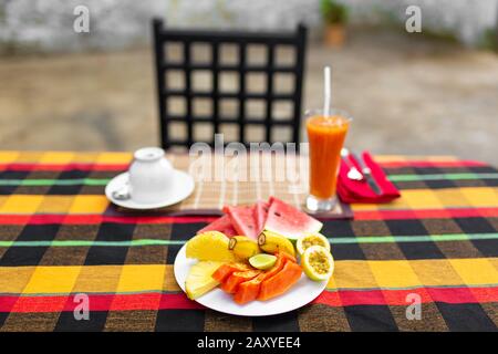 Assiette de fruits. Fruits frais et juteux dans une assiette sur un fond de montagnes. Banque D'Images