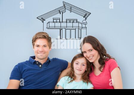 Jeune Famille Assis Sur Canapé Pensant À Obtenir Leur Nouvelle Maison Banque D'Images