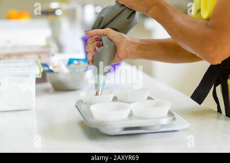 Femme chef pâtissière professionnel pâte à tartiner la pâte au chocolat dans le plat de cuisson. Banque D'Images