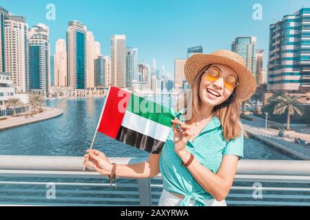 Femme tenant le drapeau national des Émirats arabes Unis, tout en se tenant dans le quartier de Marina de Dubaï Banque D'Images