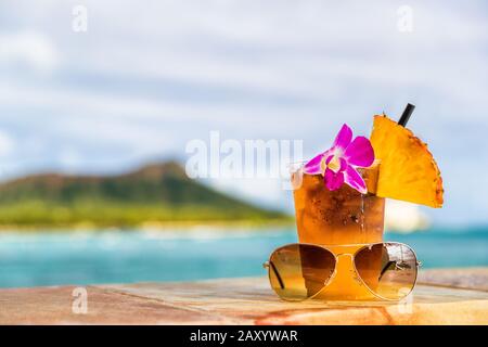 Cocktail Hawaii mai tai sur le bar de la plage de waikiki avec fleurs, ananas et lunettes de soleil. Vue sur l'océan et la montagne à tête de diamant à Honolulu, Hawaï. Vacances d'été. Banque D'Images