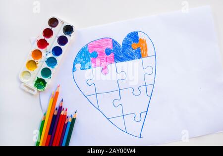 Coeur coloré dessiné par enfant avec puzzle sur fond blanc comme symbole de l'autisme, avec des crayons colorés et des aquarelles. Banque D'Images