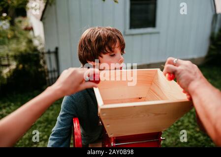 Père et deux enfants pressant des pommes pour faire du cidre, États-Unis Banque D'Images