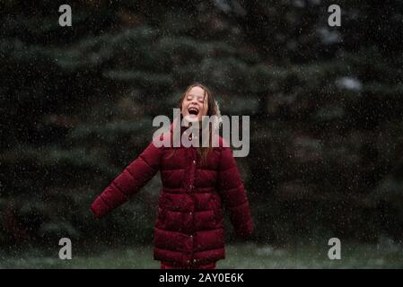 Heureuse fille debout à l'extérieur dans la neige, États-Unis Banque D'Images