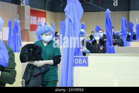 (200214) -- WUHAN, 14 février 2020 (Xinhua) -- les travailleurs médicaux se préparent à l'hôpital temporaire de Jiangxia à Wuhan, capitale de la province de Hubei en Chine centrale, 14 février 2020. L'hôpital temporaire Jiangxia, un hôpital de 400 lits converti d'un centre sportif extérieur, devrait recevoir vendredi COVID-19 patients présentant des symptômes légers. L'hôpital est le premier hôpital temporaire qui adoptera principalement le traitement des médicaments chinois traditionnels (TCM) pour guérir les patients. (Xinhua/Cheng Min) Banque D'Images