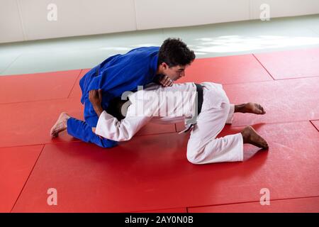 Judokas pratiquant le judo pendant un entraînement dans une salle de sport Banque D'Images