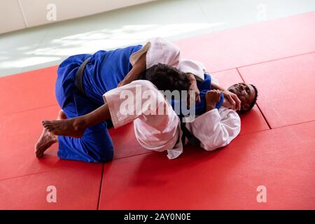 Judokas pratiquant le judo pendant un entraînement dans une salle de sport Banque D'Images